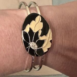 Silver tone bangle bracelet, black enamel flower, cream enamal leaves